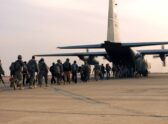 Repliegue logístico de tropas y equipo militar estadounidense desde una base en Irak, no un combate — carga de vehículos/material en una pista o instalación aeroportuaria