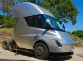 Un camión eléctrico tipo Tesla Semi ya entregado, en un patio de logística o planta industrial, que comunique 'camión eléctrico de carga en operación real' más que 'concepto o prototipo'.