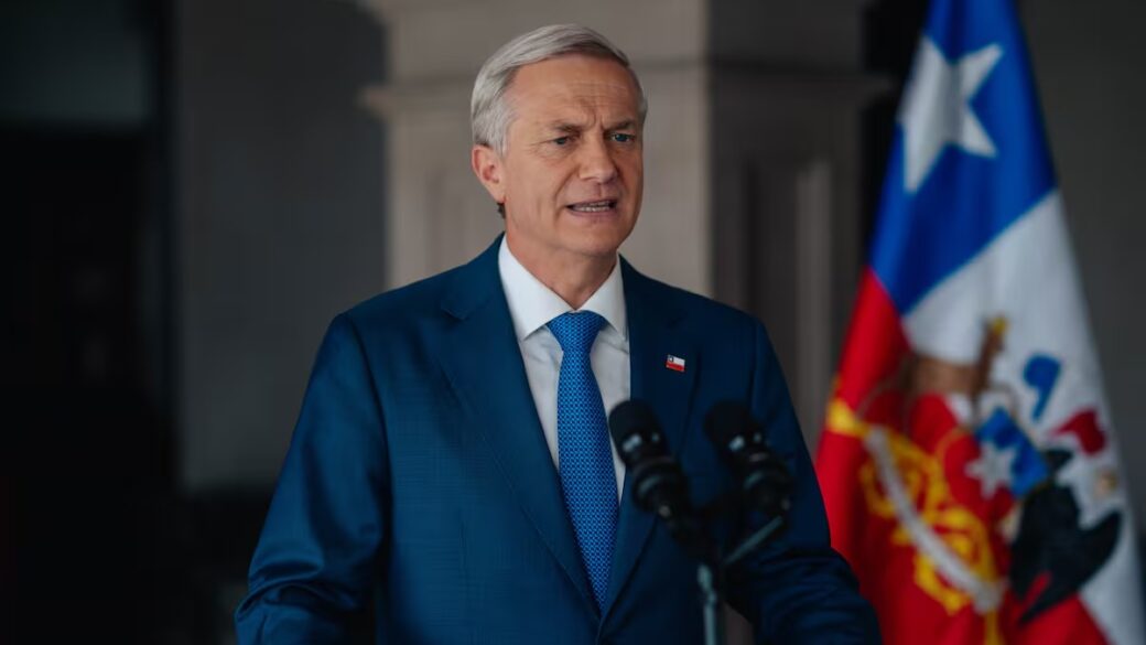 El Presidente de Chile pronunciando un discurso formal en cadena nacional desde un despacho oficial, con bandera y escudo nacional visibles, presentando el Presupuesto 2027