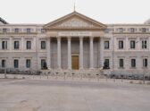 Una acampada o concentración de protesta por la crisis de vivienda en una plaza española, con carpas y pancartas, que comunique visualmente la movilización social sin depender del titular.