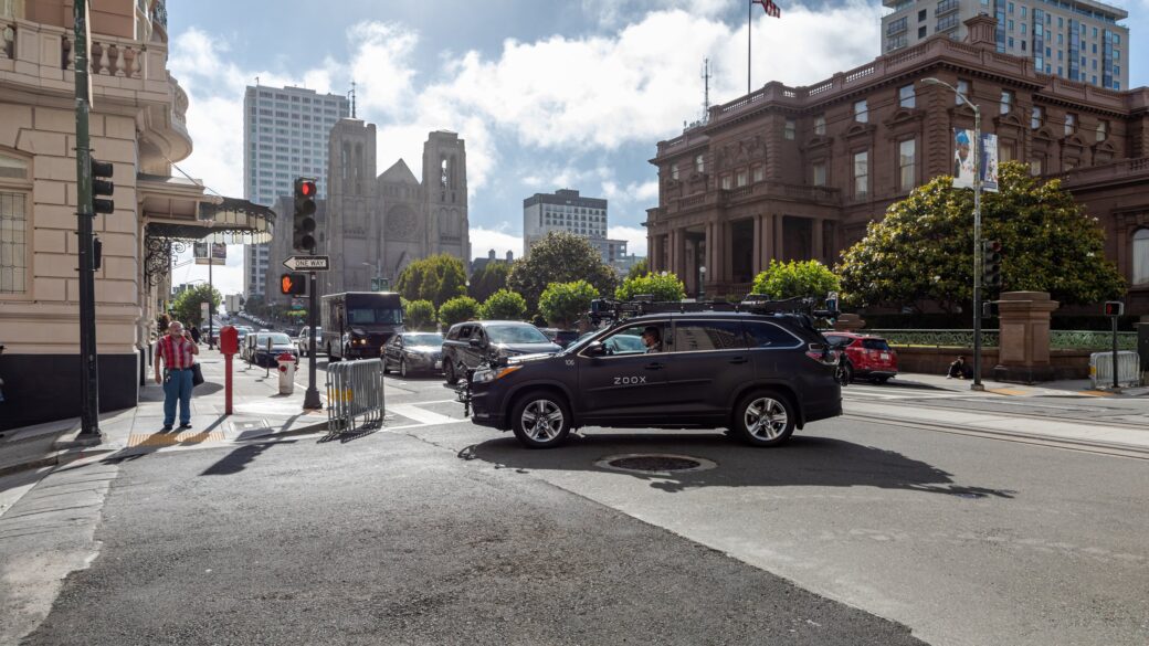 Un robotaxi (vehículo autónomo sin conductor, con sensores LIDAR visibles) detenido en una calle urbana de California