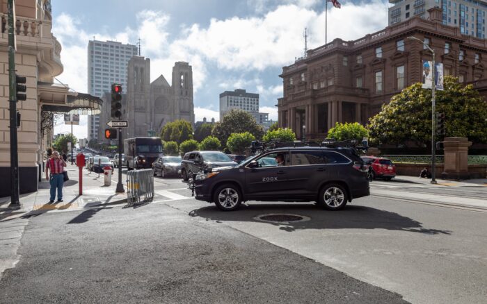 Un robotaxi (vehículo autónomo sin conductor, con sensores LIDAR visibles) detenido en una calle urbana de California